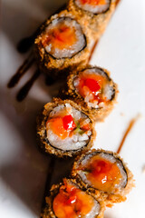 tempura sushi with sauce on a rectangular plate