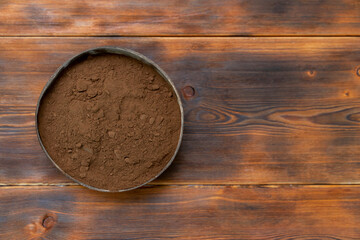 Carob powder in a natural coconut bowl, copy space