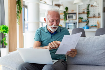 Naklejka premium Surprised laughing happy old mature retired man looking through paper document, feeling excited analyzing financial information, getting taxes refund or bank loan approval at home.