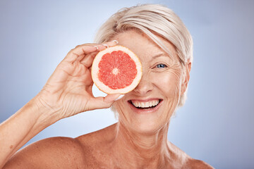 Beauty, mature woman and grapefruit portrait with a woman for skincare and wellness on a grey...