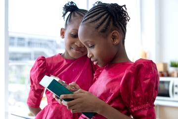 Twin African girls are interested and playing Kalimba or Thumb Piano acoustic music instrument from...