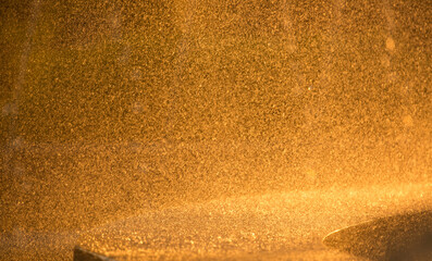 Drops of water splatter fly with yellow golden rays of the sun at sunset concept of freshness drink, watering the rain source of clean water fountain, copy space