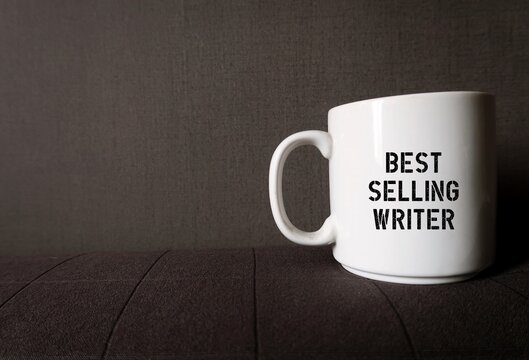 White coffee cup mug on gray copy space background with printed text on the side BESTSELLING WRITER, refers to a successful author or passionate , goat setting writer who aim to be one