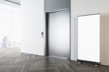 Perspective view on blank white poster on wooden parquet floor in sunlit modern office hall with light wall, metallic elevator doors and city view from panoramic windows. 3D rendering, mockup