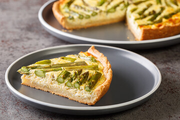 Spring creamy asparagus tart close-up in a plate on the table. Horizontal