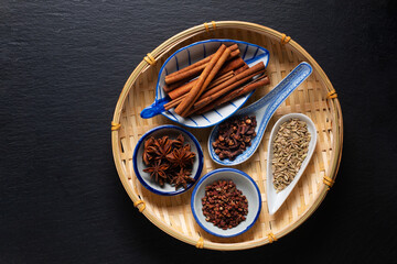 Food concept origin Chinese Five Spice  Star Anise, Fennel Seeds, Szechuan Peppercorns, Whole Cloves and Cinnamon Stick on black  background with copy space