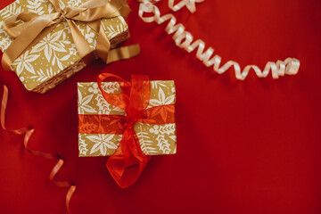 two gift boxes on a red background. christmas gifts decorated with beige and red ribbon.	
