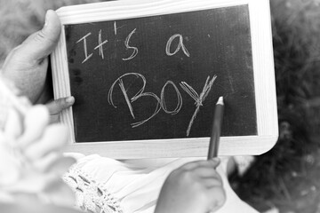 A chalkboard handwriting announces to the world the birth of a male child.