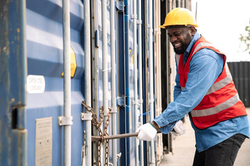 African American engineer break a crowbar to open the door of a container chained to his...