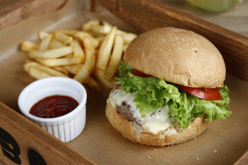 American cheeseburger with lettuce and tomato, fries and ketchup