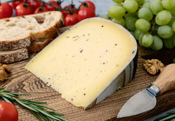 А piece of cheese with truffle on a cutting board