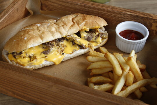 Philly cheesesteak with French fries and ketchup, lemonade