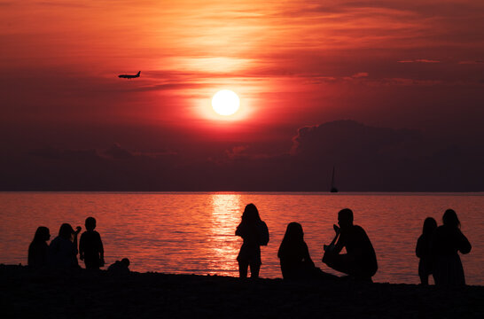 Silhouettes of people on the background of the sunset. Stunning beautiful sunset on the sea.