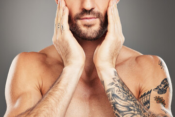 Beauty, skincare and body with a man model in studio on a gray background with an arm tattoo for...
