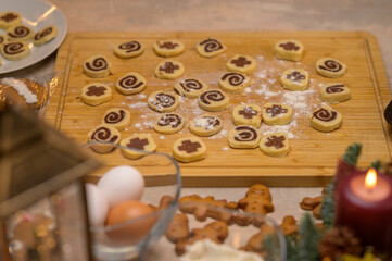 Raw Christmas cookies from fresh dough on a wooden board with seasonal decor