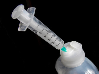 The syringe is taking the medicine on a black background. Close-up