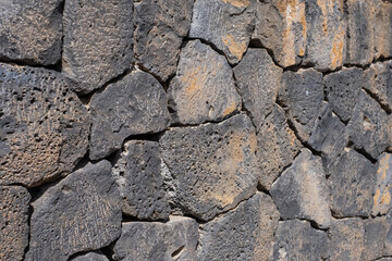 Open plan of the textures of the stones of an ancient wall. Black volcanic stone wall.black volcanic stone blocks. Tenerife, Canary Islands, Spain. 