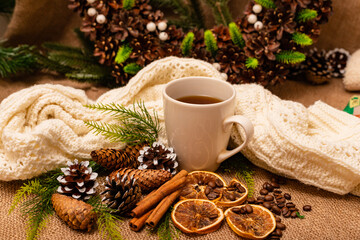 Fototapeta na wymiar Christmas composition spruce cones, cup, citrus, cinnamon on burlap
