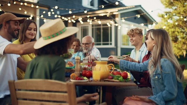 Family and Multiethnic Diverse Friends Gathering Together at a Garden Table. People Eating Grilled and Fresh Vegetables, Sharing Tasty Salads for a Big Family Celebration with Relatives.