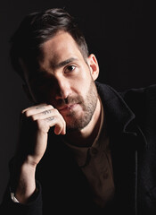 Shadow, fashion and dark portrait of man with confident attitude, designer clothes and luxury outfit. Alluring Model face of vintage gentleman with 1920s aesthetic style isolated on black background