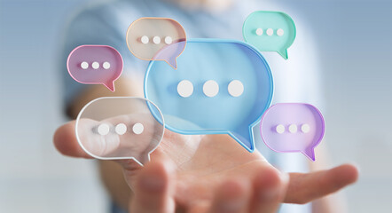 Businessman using digital speech bubbles talk icons. Minimal conversation or social media messages floating over user hand. 3D rendering © sdecoret