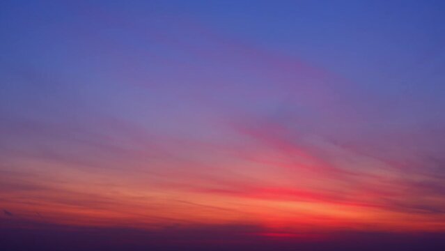 4K UHD : sky timelapse, Burning sky and shining, Red purple orange blue pink. Romantic colorful sky and sunrise clouds. winter sky. weather and the movement of nature concept
