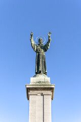 Fototapeta premium Bronze monument to St Francis of Assisi in Risorgimento Square, built in early 20th century, Milan, Lombardy region, Italy