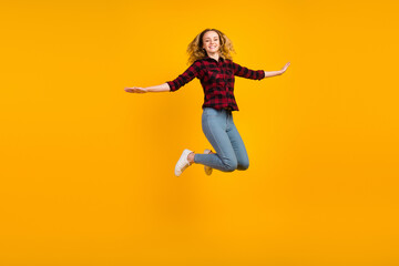 Fototapeta na wymiar Full size view of lovely glad wavy-haired girl jumping having fun rising hands isolated on vivid shine vibrant background