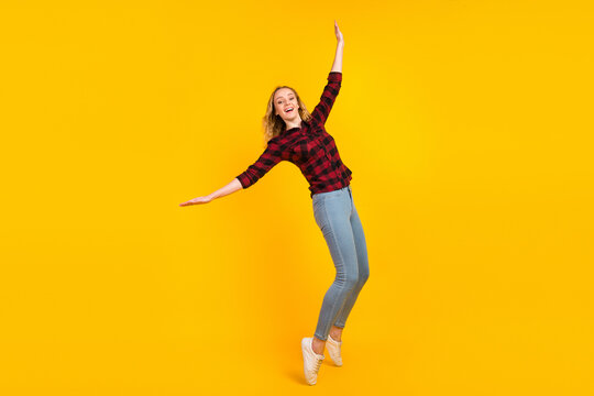 Full size view of nice-looking cheerful glad wavy-haired girl having fun isolated on vivid color background