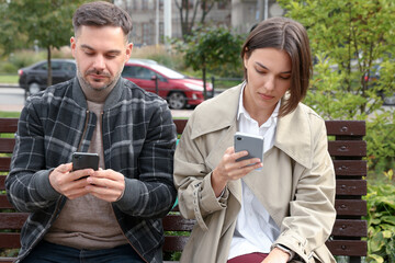 Couple preferring smartphones over spending time with each other outdoors. Relationship problems