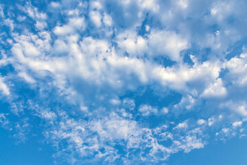 Clouds in the blue sky. Natural sky background texture, beautiful color. Peaceful blue sky with light clouds. The free form beauty of clouds and sky is perfect for background, backdrop and wallpaper.