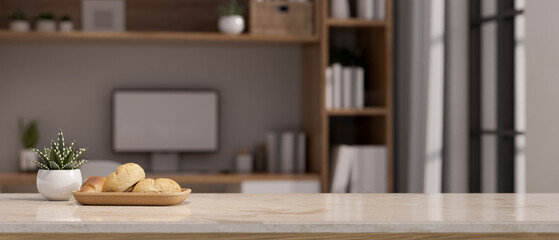 Copy space on white marble tabletop over blurred modern home workspace in background.