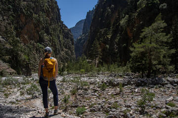 A hiker with a backpack enjoys the view in the Samaria Gorge on the Greek island of Cret