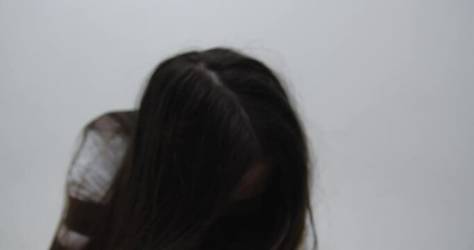 Extreme close up  of teenager girl with   long red hair, dressed in straitjacket, barefoot, tied with straps, sits in the corner of Ward in mental hospital.exacerbation of schizophrenia