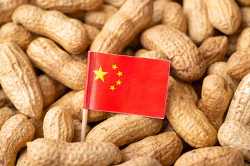 Small flag of China on unpeeled peanuts. Concept of growing peanuts in China