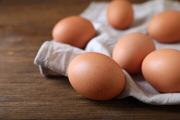 Raw brown chicken eggs on wooden table, closeup