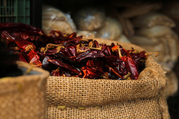 Pile of dried guajillo peppers in burlap, closeup