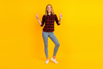 Fototapeta na wymiar Young smiling successful woman in shirt show victory v-sign gesture isolated on bright color background studio portrait