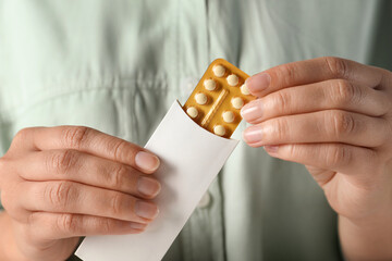 Woman holding blister of oral contraceptive pills, closeup - obrazy, fototapety, plakaty