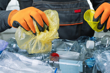 close-up, worker sorts trash on conveyor belt. man working in a recycling factory.