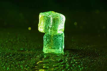 Green ice cubes on black background.