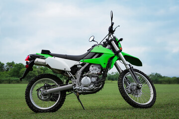 Obraz na płótnie Canvas Stylish cross motorcycle on green grass outdoors