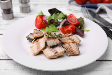 Delicious canned mackerel chunks served on white wooden table, closeup