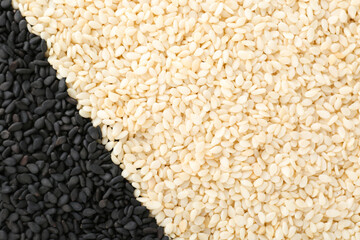 Black and white sesame seeds as background, top view