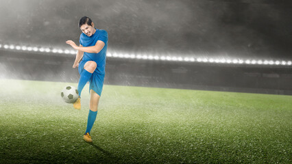 Asian football player man in a blue jersey kicking the ball
