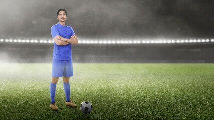 Asian football player man in a blue jersey standing with the ball