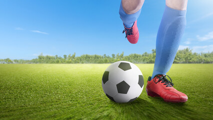 Football player man in a blue jersey kicking the ball