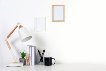 Obraz na płótnie Canvas Comfortable workplace with white desk near wall at home