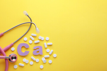 Stethoscope, pills and calcium symbol made of purple letters on yellow background, flat lay. Space for text