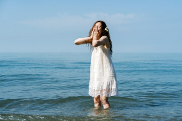 Fototapeta na wymiar Happy emotional expressive young beautiful woman enjoying cool sea water in summer day. Summer vacation concept.